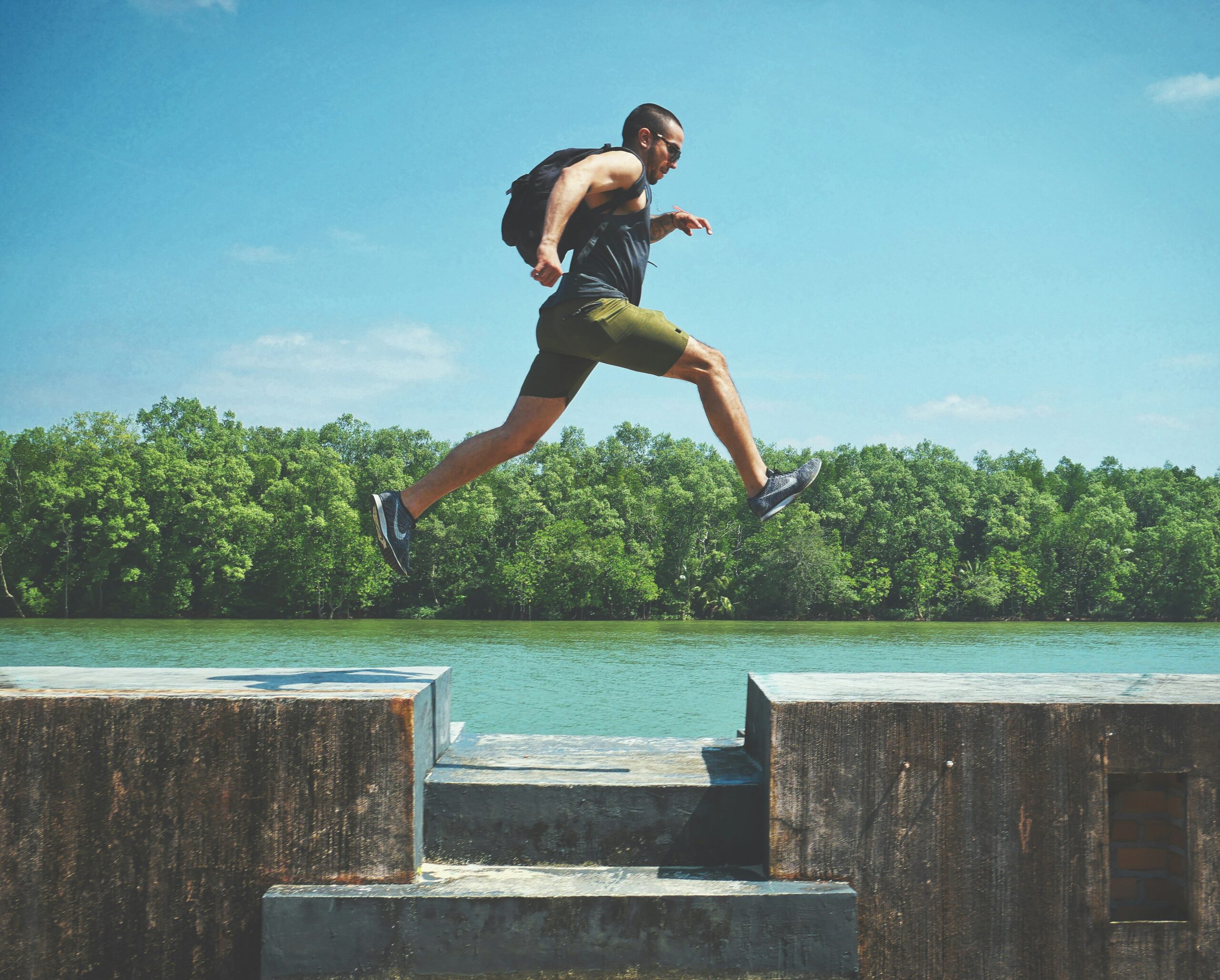 A picture of a man running and crossing a river.